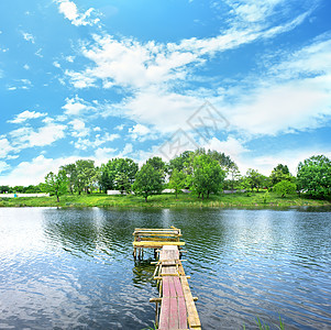 伍德码头衬套木头日光天空气候树木公园池塘蓝色钓鱼图片