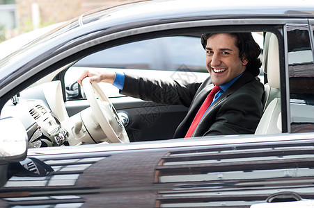 公司的人驾驶他的车内饰老板方向盘雇主套装车辆管理人员商务汽车企业家图片