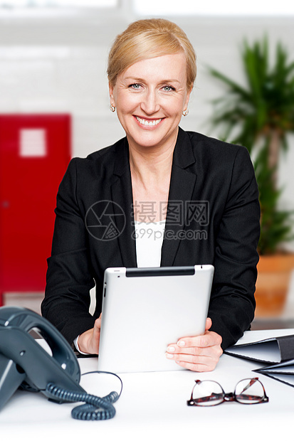 办公桌上有平板电脑的女商务人士图片