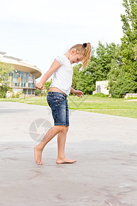 可爱的女孩跳着一条腿跳孩子舞蹈蓝色白色女学生童年金发背景图片