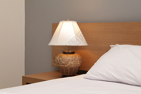带床铺的台灯床罩枕头家具床头板桌子白色公寓酒店灯光卧室背景图片