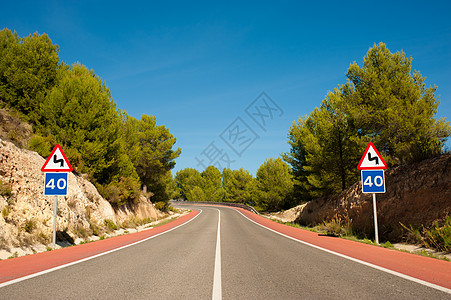 风景道路警告晴天极限水平标志曲线交通孤独森林速度图片