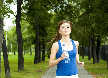 夏天在公园慢跑的年轻女子练习运动火车行动自由运动员身体阳光运动服成人图片