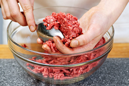 手打牛肉土牛肉烹饪倾斜食谱食物柜台牛肉肉丸勺子台面厨房玻璃背景