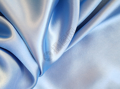 平滑优雅的蓝色丝绸作为背景投标折痕布料银色曲线织物材料纺织品图片