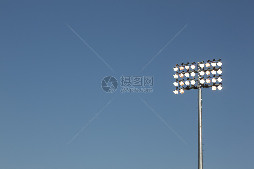 蓝色天空背景的球场灯光棒球棒球场蓝天白色物体设备联盟电灯摄影低角度图片