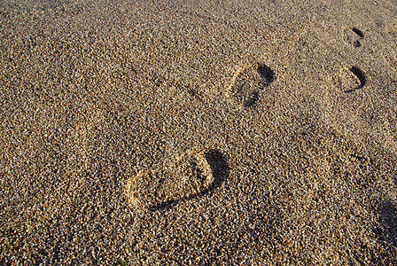 地中海海滩上的脚印 日落时间 作为背景痕迹印刷粒状假期旅游支撑小路脚步打印烙印图片