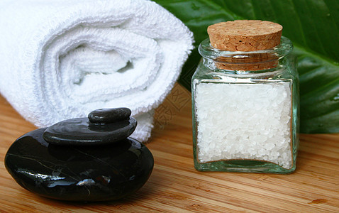 白浴巾 一瓶海水盐和调味料的石头图片