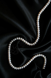 黑天鹅绒上的白珍珠宝石展示项链魅力象牙白色细绳光泽度奢华丝绸图片