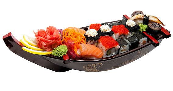 寿司船木板上的一套寿司 以船的形式午餐文化拼盘橙子蔬菜海鲜晚餐食物萝卜团体背景