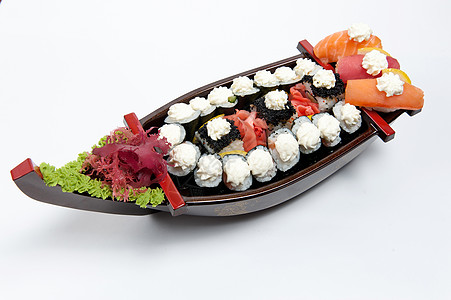 寿司船木板上的一套寿司 以船的形式美食海鲜美味晚餐蔬菜鱼片食物午餐团体拼盘背景