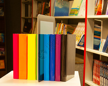 书店中彩色书籍和平板电脑阅读器图片