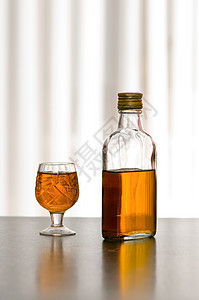 瓶装威士忌玻璃黄色棕色饮料瓶子桌子酒杯酒精背景图片