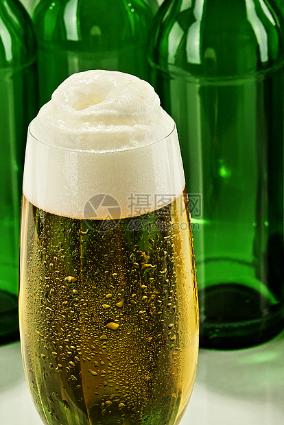 啤酒瓶子黄色金色啤酒杯郁金香酒精玻璃泡沫图片