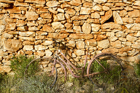 古老的自行车在石墙上生锈 浪漫忧郁图片