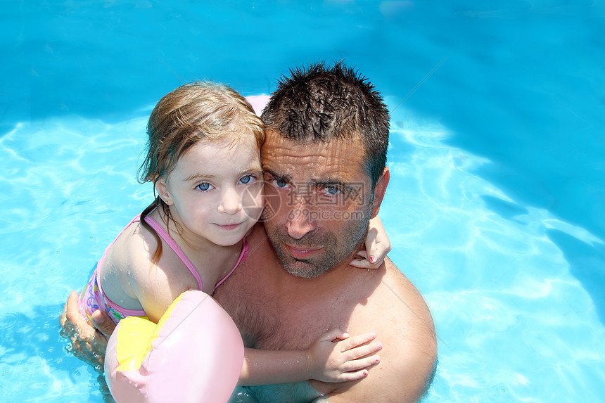 父亲女儿在蓝游泳便便上拥抱图片