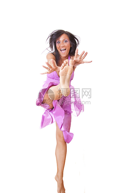 穿着紫色丝绸服的笑女跳跃图片