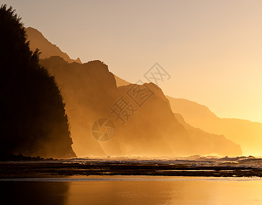 Na Pali海岸线的米丝日落海洋蓝色悬崖薄雾沿海天空橙子支撑海岸波浪图片