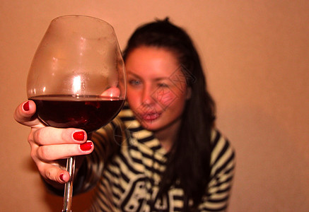 一个年轻女子 喝了一杯红酒派对玻璃相机活动玫瑰酒杯享受乐趣食物衣服图片