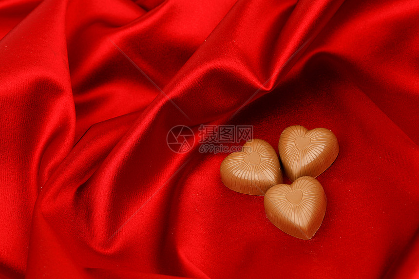 红沙子上的糖果心盒子食物丝带展示巧克力正方形甜点礼物生日奢华图片
