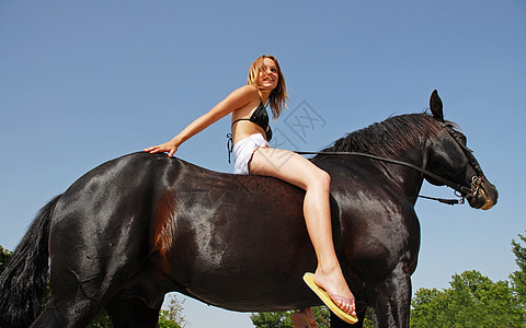 骑马女童披肩黑色金发浴衣白色运动蓝色动物天空幸福图片