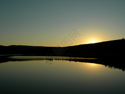 日落和平静的湖泊天空镜子森林池塘反射蓝色风景辉光地平线湿地图片