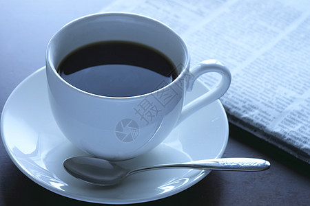 一杯热咖啡和报纸咖啡杯子咖啡店桌子白色早餐黑色勺子休息图片