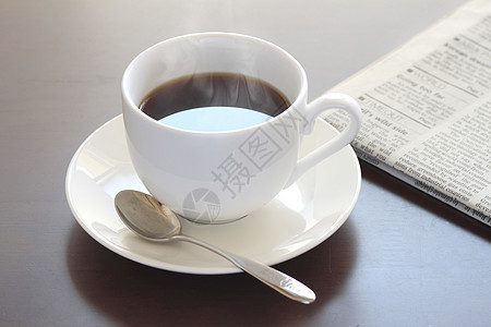 一杯热咖啡和报纸桌子休息早餐勺子黑色杯子白色咖啡咖啡店图片
