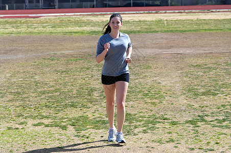 演习演练慢跑运动车道跑步女孩女性青少年赛跑者背景图片