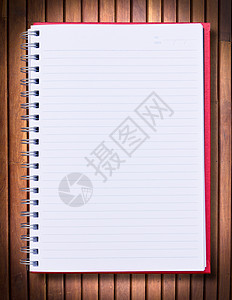 木材背景上的红色笔记本戒指笔记木炭教育大学考试文档绘画家庭作业学习图片