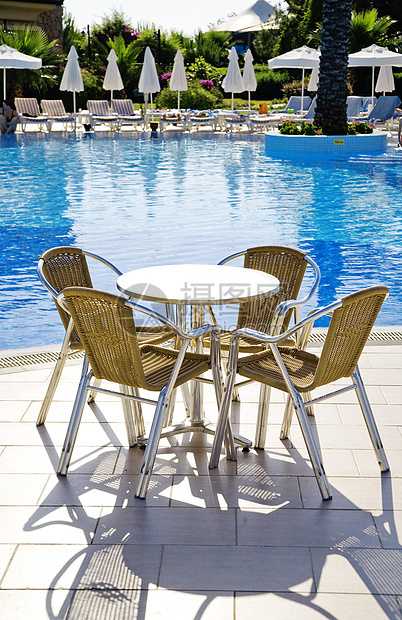 桌椅和椅子靠近一个凉爽的游泳池假期文化派对饮料热带旅行天空水池用餐图片