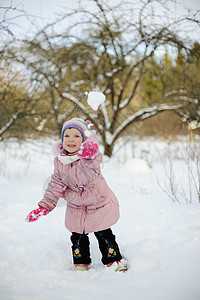 小女孩玩雪球行动童年女孩幸福乐趣季节图片