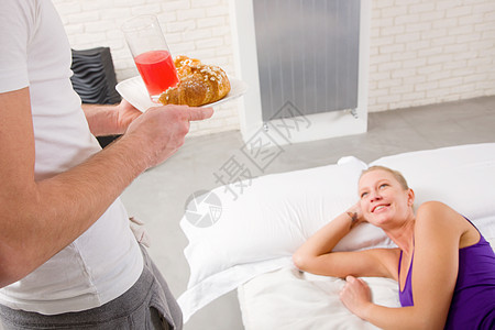 睡在床上的女男子做早餐玻璃托盘羊角说谎长发男人日常生活饮料微笑好心情图片