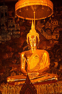 坐在佛像旁边的泰国金子佛教徒雕像旅行旅游雕塑建筑学宗教寺庙寺院图片