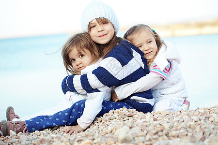 海滩上的孩子拥抱女孩们儿童孩子们闲暇衣服友谊童年朋友们团体图片