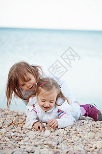 海滩上的孩子乐趣拥抱青年朋友们衣服童年孩子们儿童快乐女孩们图片