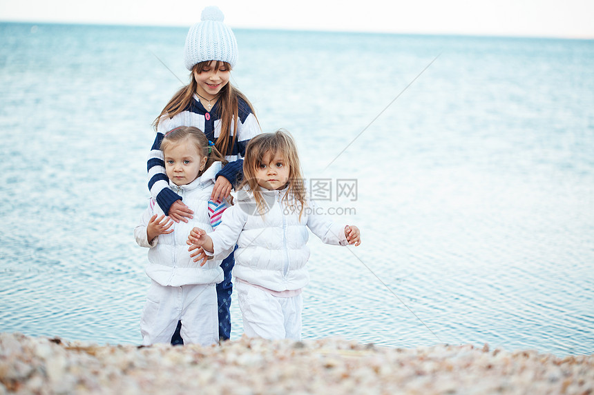 海滩上的孩子游戏姐妹儿童乐趣友谊童年女孩们闲暇团体孩子们图片