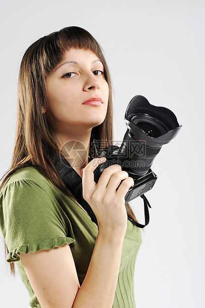 年轻女孩举起相机单反镜片青年女孩们摄影师影棚图片