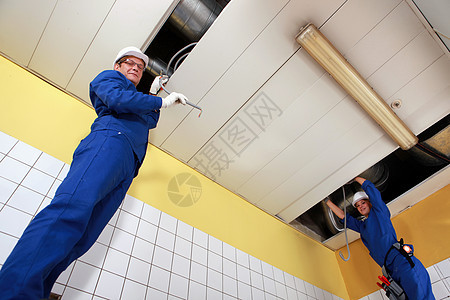 电工在一间大房间布线男性团队工业网络基础设施天花板电气技术空调安装图片