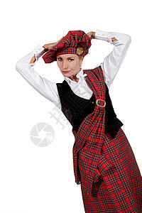一个穿着苏格兰服装的年轻女人 看着我们看她图片