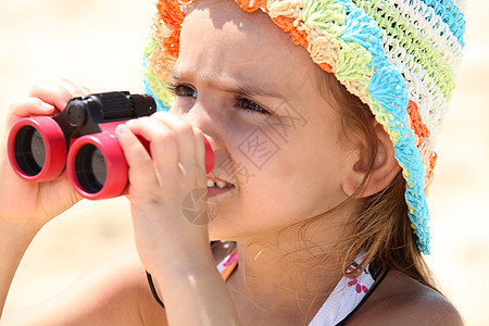 沙滩上的小姑娘带着望远镜女儿高清图片素材