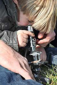 使用显微镜户外显微镜的好奇小男孩户外的高清图片素材