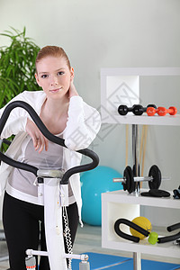 体操中的年轻女子自行车疾病椭圆机女士中心运动活力力量灵活性跑步机图片