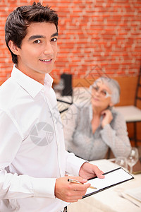 年轻服务员在餐厅订餐时点菜食物软垫菜谱客户菜单工作职业男人服务器命令背景图片
