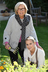 母亲和女儿的园艺帮助妈妈金发植物退休父母白色老年女性头发图片