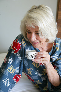 灰色头发的女士喝清晨咖啡图片
