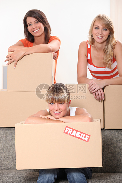 三名女青年在房间里装满无包装的包裹图片