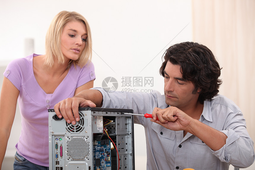 男子用妇女看电视来修理电脑图片