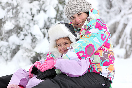 母亲和女儿一起在雪中玩耍童年纽带乐趣培育喜悦寒冷女士女性家庭生活背景