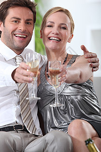 一对夫妇坐下来 拿着香槟杯的手举起图片